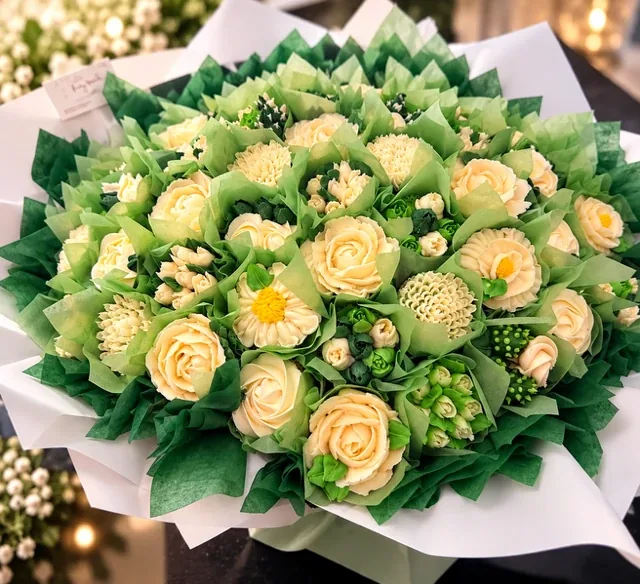 Bouquet de cupcakes décorés de fleurs en crème ivoire et vert