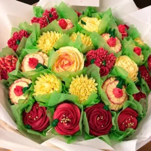 Bouquet de cupcakes décorés de roses rouges et de fleurs jaunes en crème