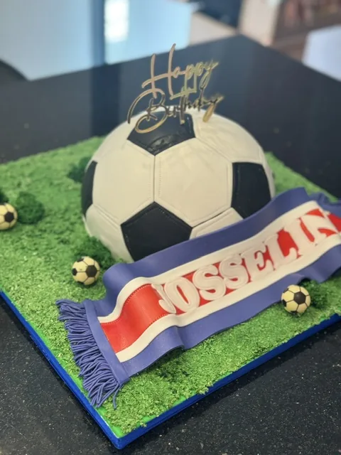 Gâteau en forme de ballon de foot sur pelouse, écharpe de supporter